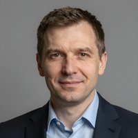 Портрет уверенного российского бизнесмена с дружелюбным взглядом на размытом нейтральном фоне в студии